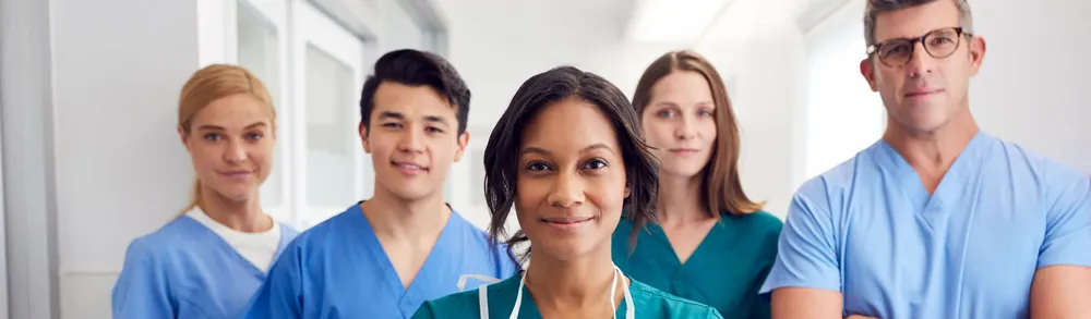 Pflegeteam in Dienstkleidung steht nebeneinander